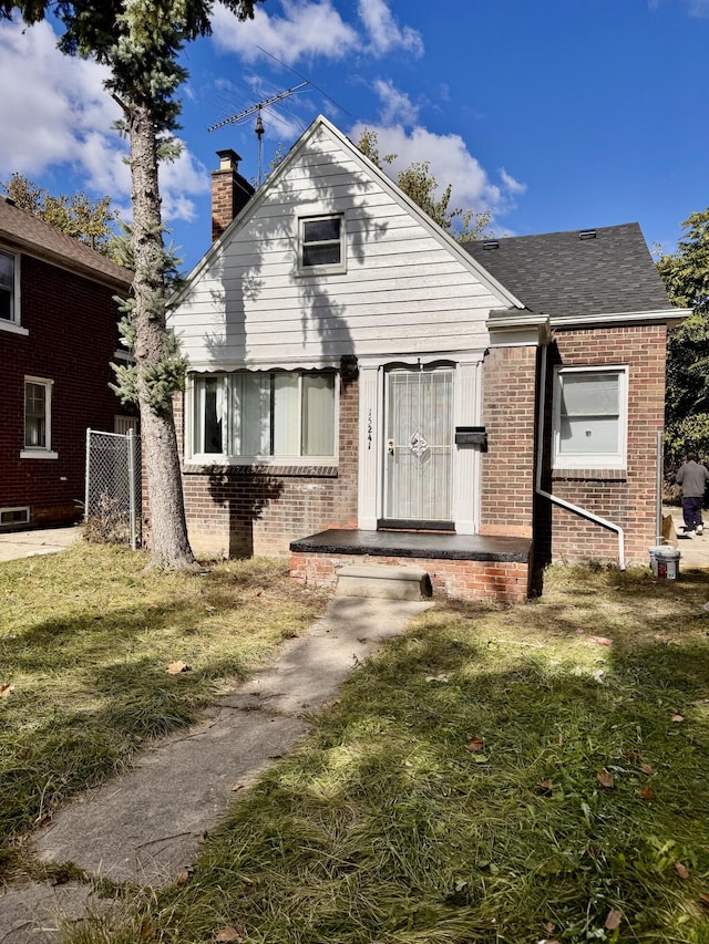 15241 Seymour St, Detroit, MI 48205 - bungalow-style house with a chimney, a front lawn, brick siding, and a shingled roof