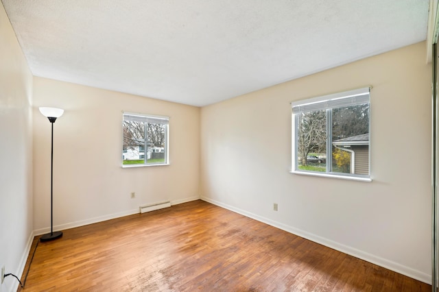 1843 N Sierra Way, Stevensville, MI 49127 - spare room with baseboard heating, hardwood / wood-style flooring, a healthy amount of sunlight, and baseboards