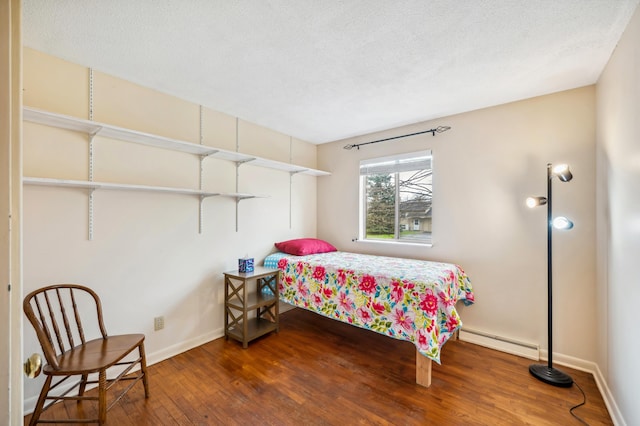 1843 N Sierra Way, Stevensville, MI 49127 - bedroom with a baseboard heating unit, wood finished floors, a textured ceiling, and baseboards