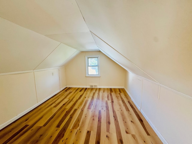 additional living space with lofted ceiling, light wood-style floors, and visible vents