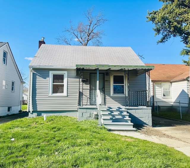 bungalow with a porch, a front lawn, a chimney, and fence