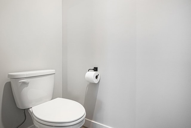 bathroom featuring baseboards and toilet