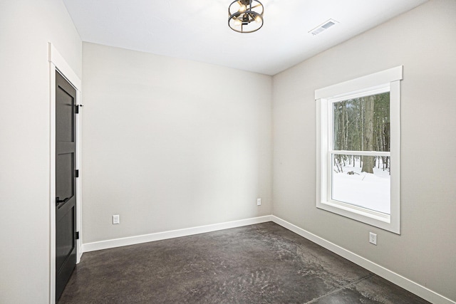 unfurnished room featuring unfinished concrete floors, baseboards, and visible vents