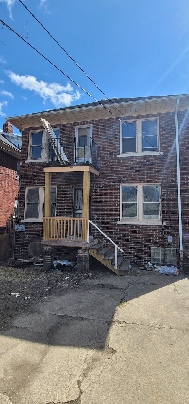view of front of home with brick siding and a balcony
