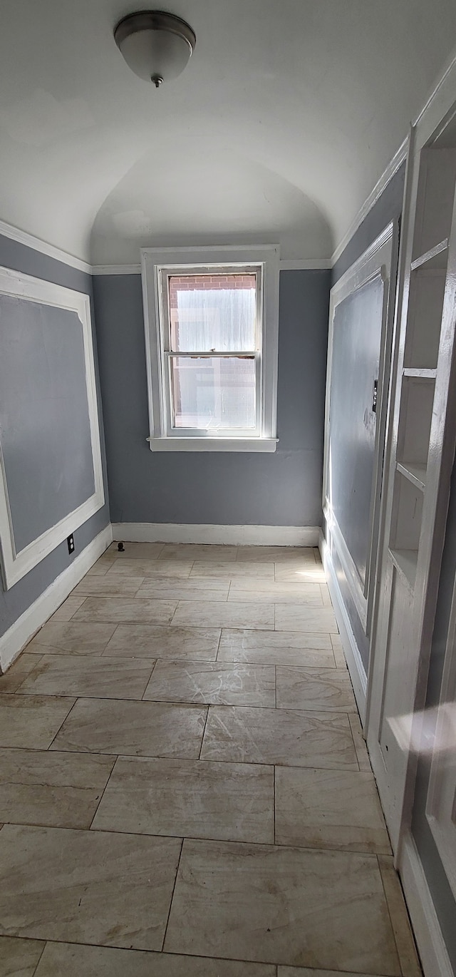 interior space featuring lofted ceiling and baseboards