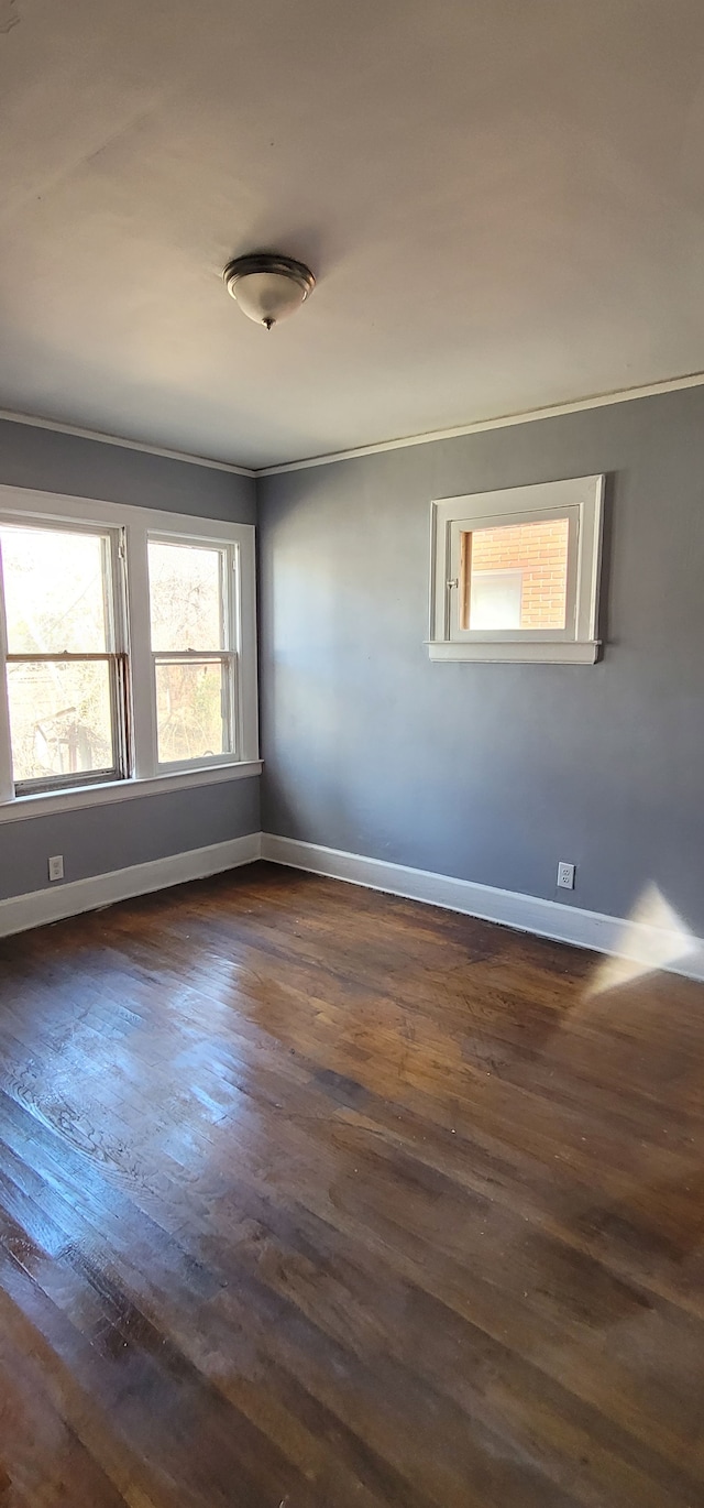 unfurnished room with dark wood finished floors and baseboards