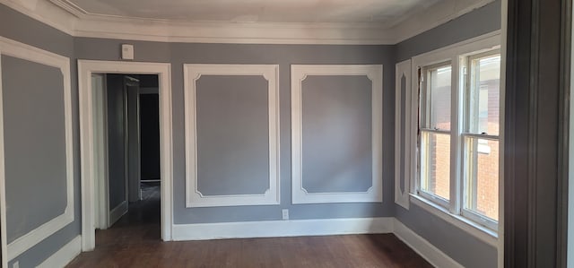 interior space featuring baseboards, wood finished floors, and crown molding