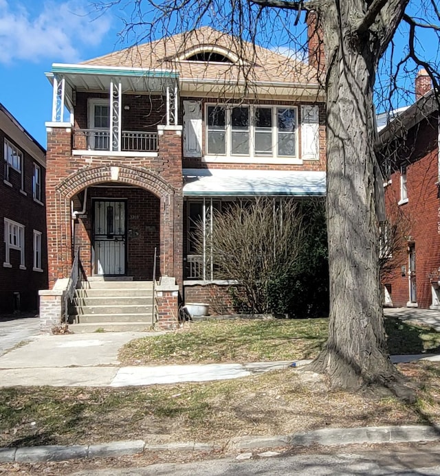 view of front of home featuring brick siding, a porch, and a balcony