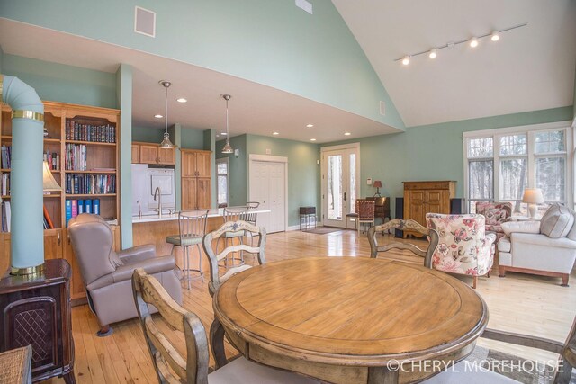 3390 E Baseline Rd, White Cloud, MI 49349 - dining space featuring high vaulted ceiling, a healthy amount of sunlight, and light wood-style floors