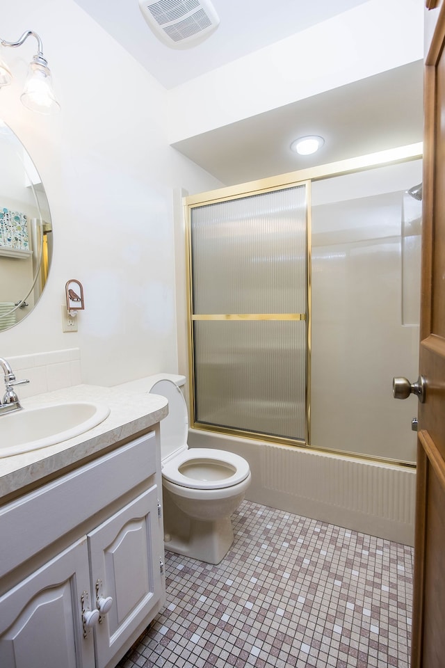 bathroom featuring toilet, shower / bath combination with glass door, tile patterned floors, visible vents, and vanity