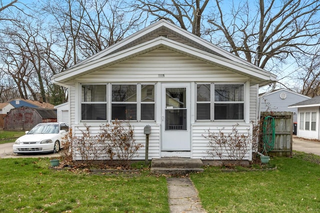view of front of house with fence, a sunroom, and a front yard