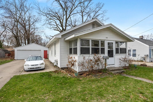 bungalow with a front lawn, an outdoor structure, and a garage