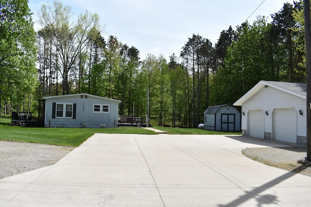 7885 W Fox Rd, Mears, MI 49436 - view of side of home with concrete driveway, a yard, and a deck