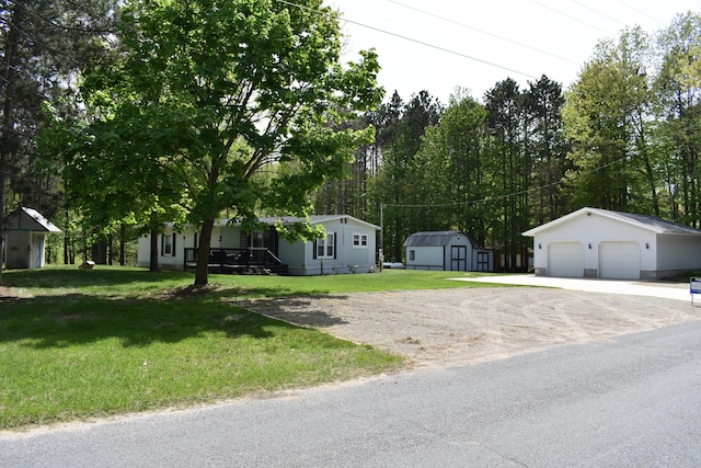 7885 W Fox Rd, Mears, MI 49436 - view of front facade featuring a garage, a front yard, and view of scattered trees