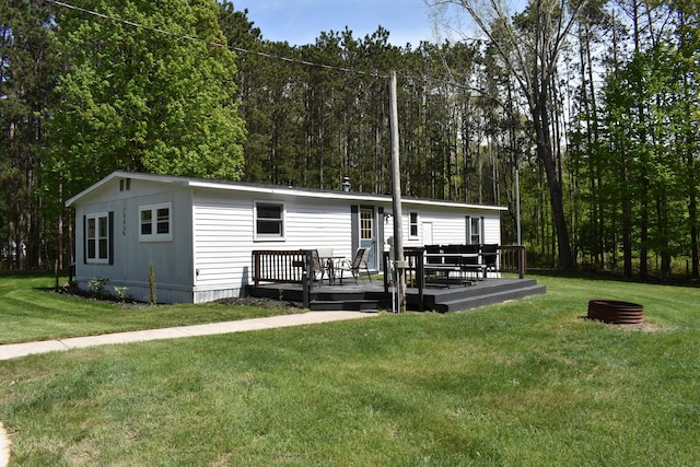 7885 W Fox Rd, Mears, MI 49436 - back of house featuring a deck, a yard, and a wooded view