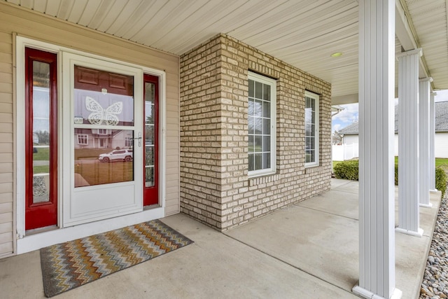 entrance to property with brick siding and covered porch
