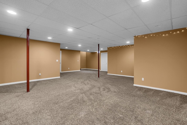 finished below grade area with baseboards, carpet flooring, recessed lighting, and a drop ceiling