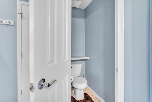 bathroom featuring toilet, tile patterned floors, and baseboards