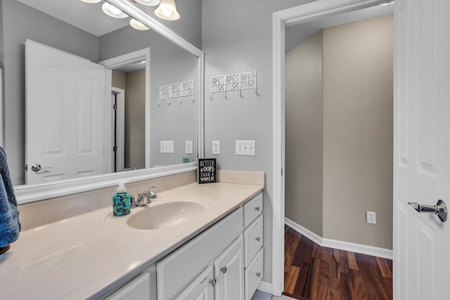 bathroom featuring baseboards, wood finished floors, and vanity