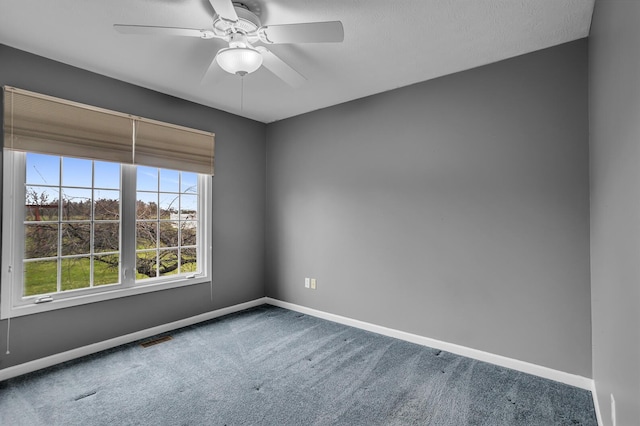 carpeted empty room featuring visible vents, baseboards, and ceiling fan