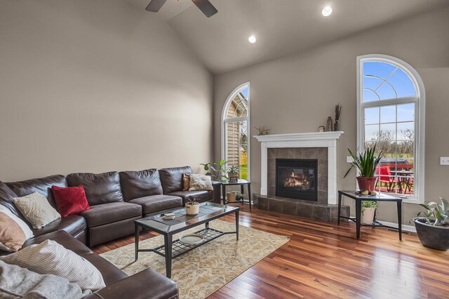 living room featuring recessed lighting, high vaulted ceiling, ceiling fan, hardwood / wood-style floors, and a fireplace