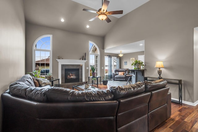 living room featuring plenty of natural light, a ceiling fan, vaulted ceiling, and dark wood-type flooring