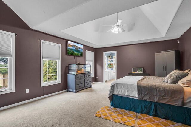 bedroom with a tray ceiling, vaulted ceiling, a ceiling fan, baseboards, and carpet flooring