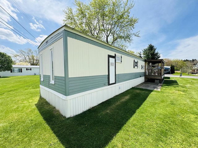 view of side of property with a lawn and a wooden deck
