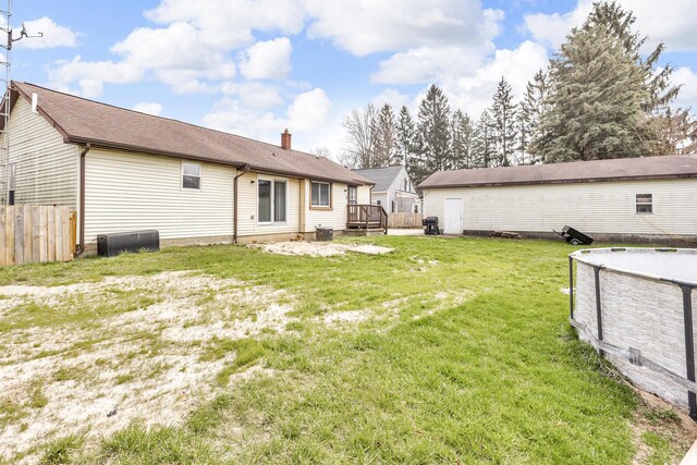 808 Longfellow Ave, Jackson, MI 49202 - back of property with a chimney, a wooden deck, fence, and a yard