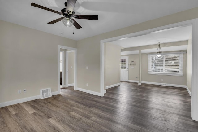 808 Longfellow Ave, Jackson, MI 49202 - empty room featuring baseboards, dark wood-type flooring, visible vents, and ceiling fan with notable chandelier