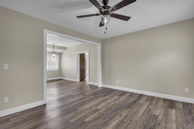 808 Longfellow Ave, Jackson, MI 49202 - spare room with baseboards, dark wood-style flooring, and ceiling fan with notable chandelier
