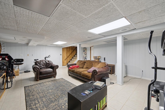living area featuring stairway, tile patterned flooring, and a drop ceiling