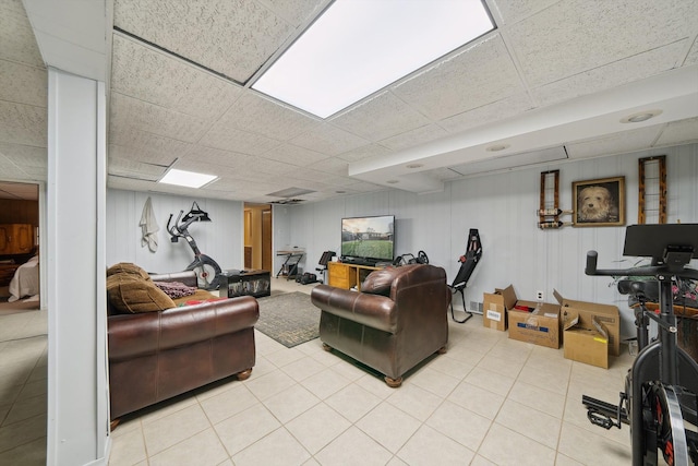 living room featuring a drop ceiling and light tile patterned floors