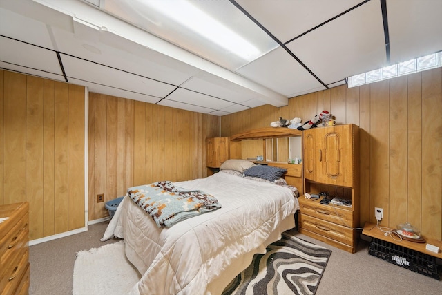 carpeted bedroom featuring wood walls