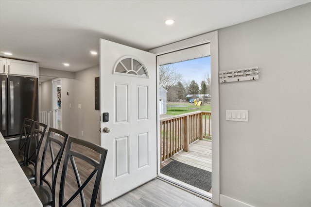 entryway featuring baseboards, recessed lighting, and light wood-style floors
