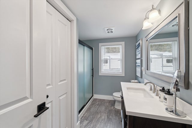 full bath featuring baseboards, toilet, vanity, and a healthy amount of sunlight