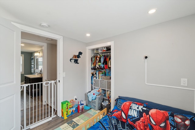 bedroom with recessed lighting, a closet, and a sink