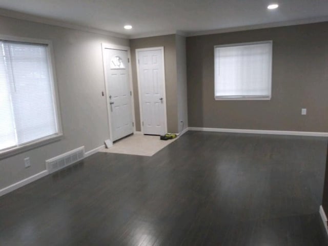 entrance foyer featuring baseboards, visible vents, and ornamental molding