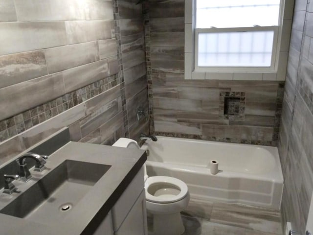 bathroom featuring bathing tub / shower combination, vanity, and toilet