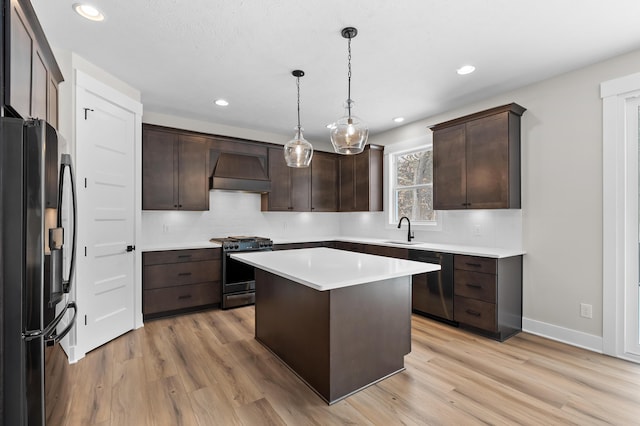 2630 Ashford Trl, Portage, MI 49024 - kitchen with dark brown cabinets, premium range hood, dishwashing machine, gas stove, and fridge with ice dispenser