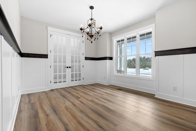 2630 Ashford Trl, Portage, MI 49024 - unfurnished dining area with a notable chandelier, french doors, wood finished floors, and baseboards