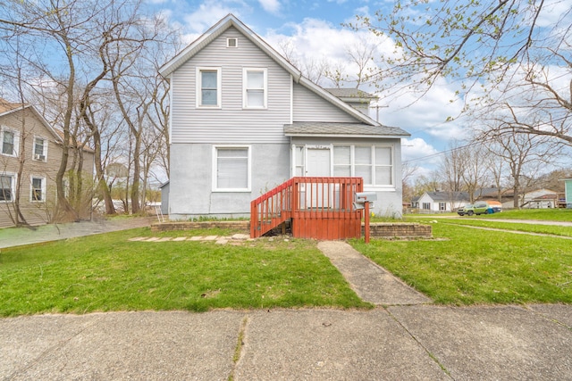 view of front of property with a shingled roof and a front lawn