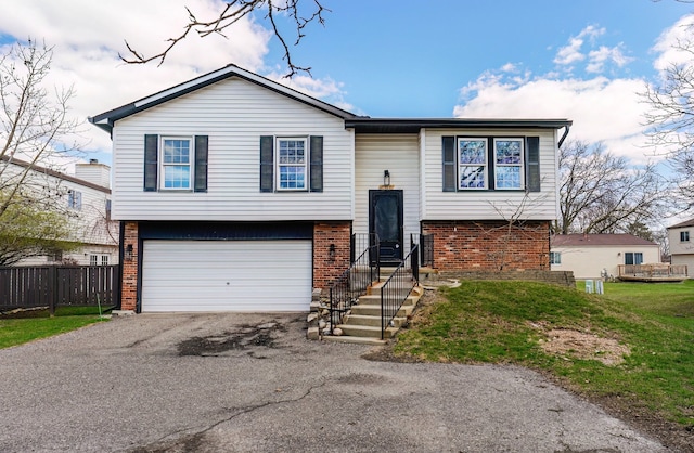 2919 Roundtree Dr, Troy, MI 48083 - split foyer home featuring brick siding, a garage, and asphalt driveway