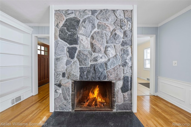 21700 W 13 Mile Rd, Beverly Hills, MI 48025 - detailed view of crown molding, wood finished floors, a stone fireplace, built in shelves, and a decorative wall