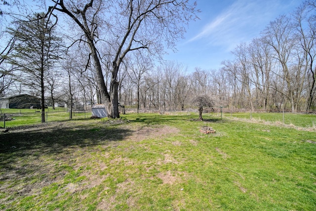 124 Broad St, Brooklyn, MI 49230 - view of yard featuring a storage unit, an outbuilding, and fence