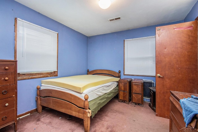 carpeted bedroom featuring visible vents