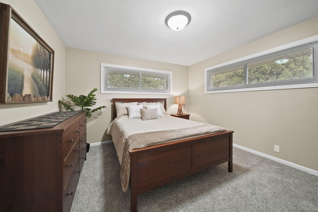 bedroom with dark carpet and baseboards