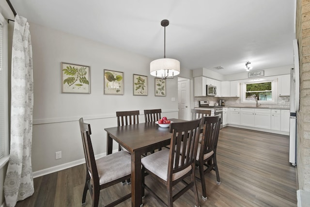 dining area with dark wood finished floors and baseboards
