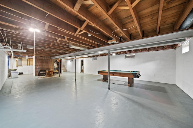 unfinished basement with concrete block wall, pool table, and stairs