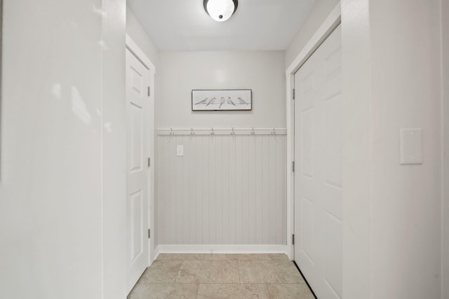 doorway with wooden walls and baseboards